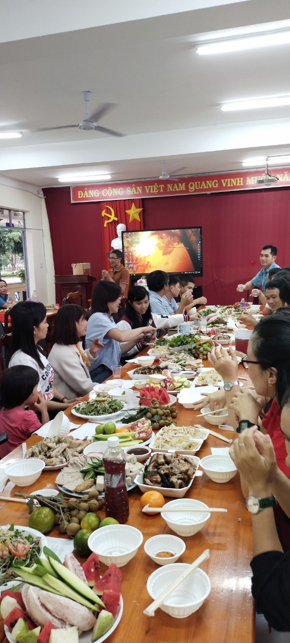 ''A group of people sitting at a table eating food

Description automatically generated''